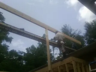 Carpenter setting a ridge beam over a new addition frame — Ice Dam Removal by Roofing Brothers in Hales Corners