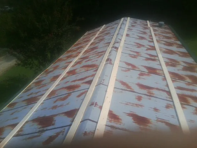 Rusted metal roof panels with new wood purlins before replacement — Storm Damage Roof Repair in Hales Corners by Roofing Brothers