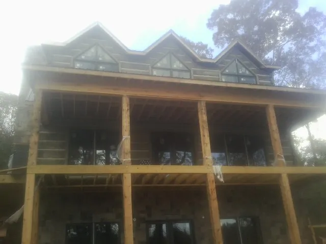 Dormers and porch framing on a large log home under construction — Roof Coating work by our crew in Hales Corners