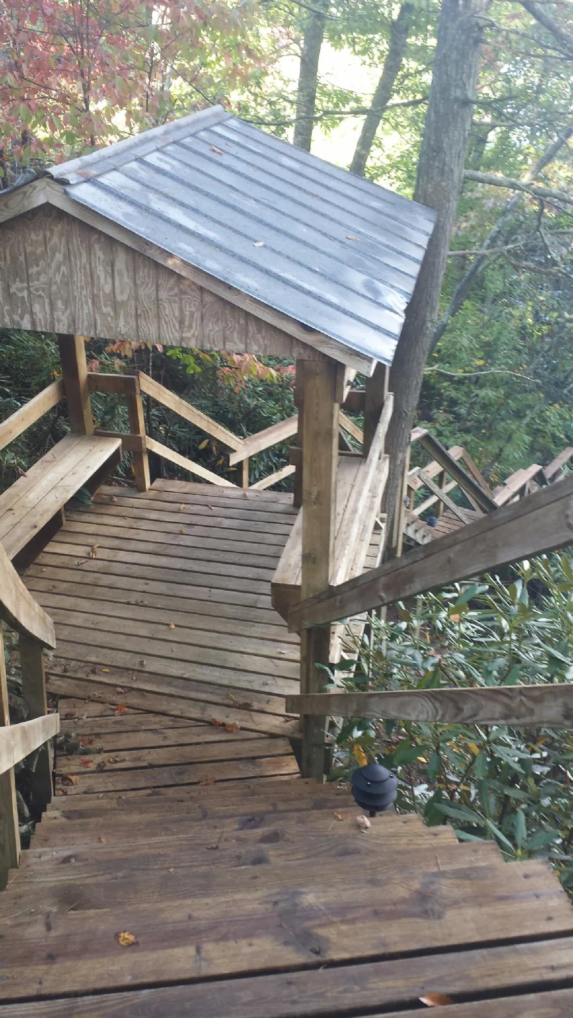Metal roofed shelter over wooden steps on a wooded walkway — Skylight Repair & Installation work by our crew in Hales Corners