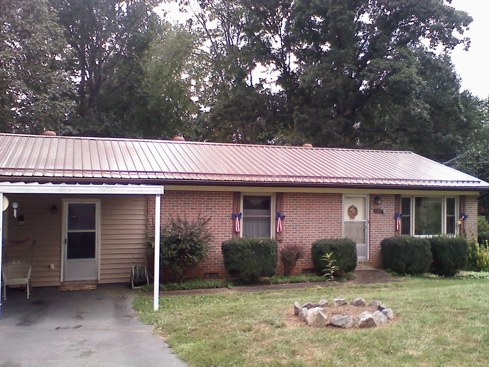 Bronze metal roof and carport on a brick ranch home — Roof Repair work by our crew in Hales Corners